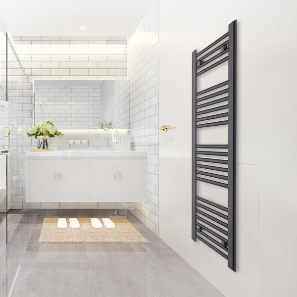 Tall black heated towel rail radiator on a bathroom wall