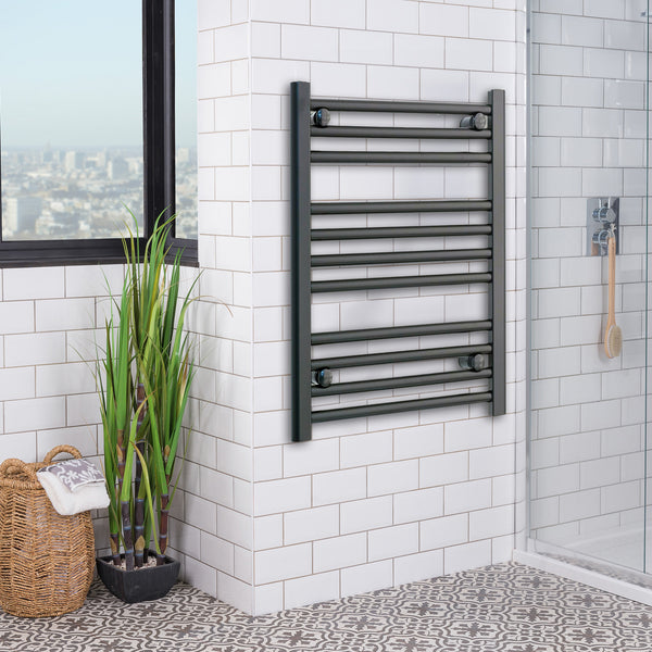 Matt black heated towel rail radiator mounted in a bathroom