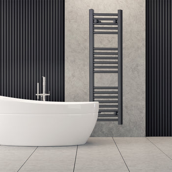 Tall black heated towel rail radiator beside a freestanding bath