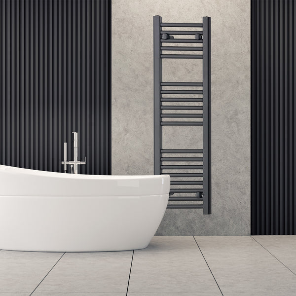 Tall black heated towel rail radiator beside a freestanding bath