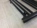 Close-up of the bottom rail and pipe connection on a black towel radiator