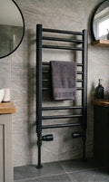 Black towel radiator with a towel in a tiled bathroom