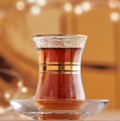 Clear glass cup with tea on a reflective surface 