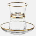 Clear glass cup with gold rim and matching saucer 